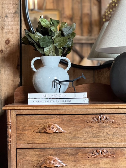 antique dresser with lamp and vase with botanicals